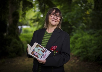 Author Ali Smith holding a copy of her prize-winning novel Gliff