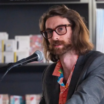 A photo of Tim macgabhann speaking at an event