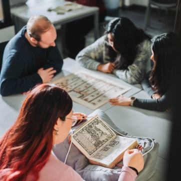 Students studying with open books on a table.