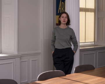 A photo of Sally Rooney standing by a window